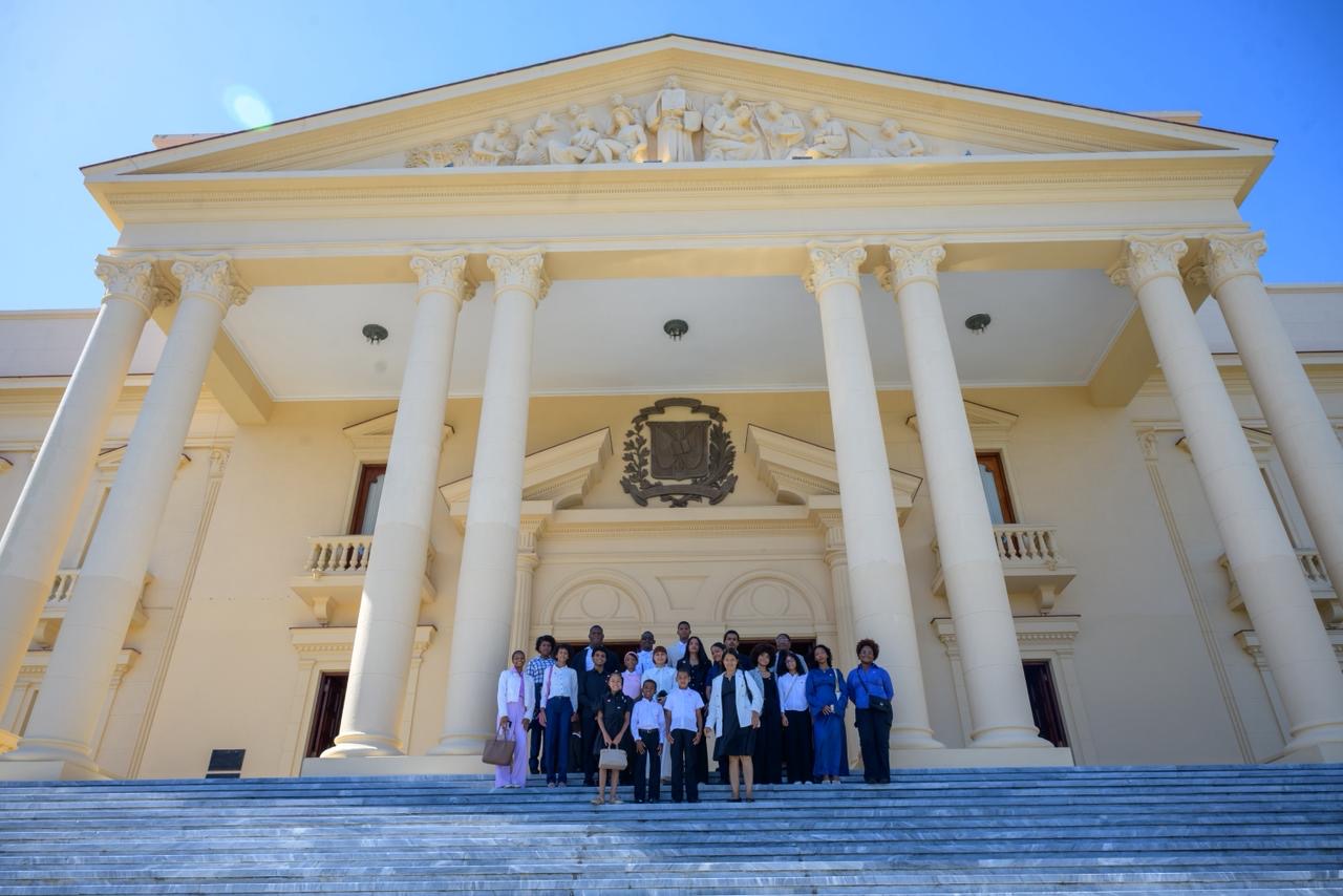 Jóvenes participantes frente a un edificio institucional dominicano